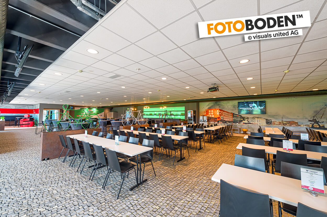 VIP Tribüne im Preussen Stadion mit FOTOBODEN™ in Objektqualität ausgestattet. Fahrradweg und Kopfsteinpflaster wurden individuell auf den Vinylboden gedruckt.